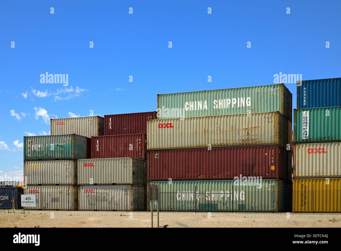 Container impilati China Shipping e OOCL nel deposito merci sotto il cielo azzurro del porto di Fremantle, Australia Occidentale Foto Stock