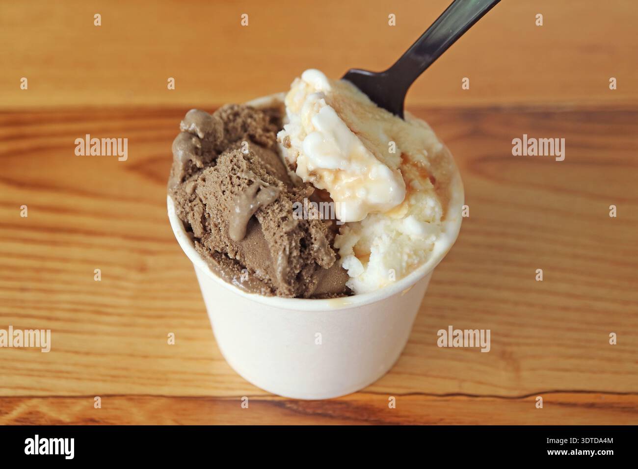Versare il cucchiaio nel delizioso gelato al caramello e al cioccolato Foto Stock