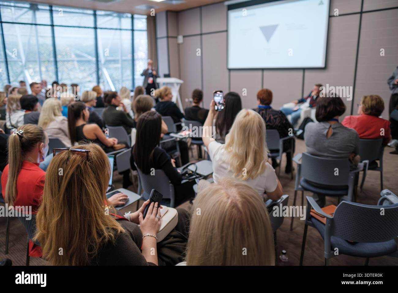 I partecipanti alla conferenza ascoltano il relatore, prendono appunti e foto, creano contatti, creano un'atmosfera da officina, imparano e si impegnano a fondo. Foto Stock