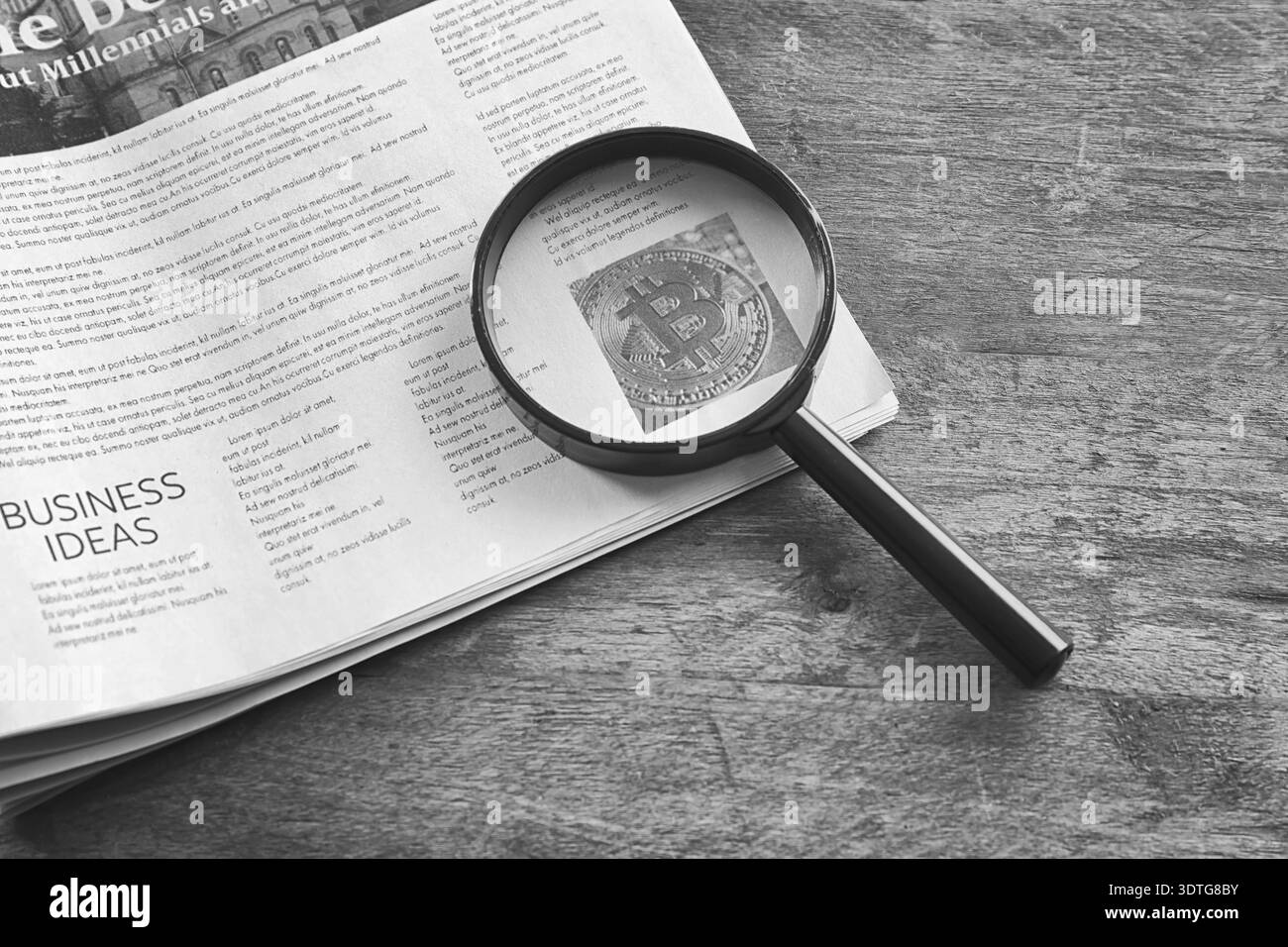 Lente d'ingrandimento e giornale su sfondo in legno, primo piano Foto Stock