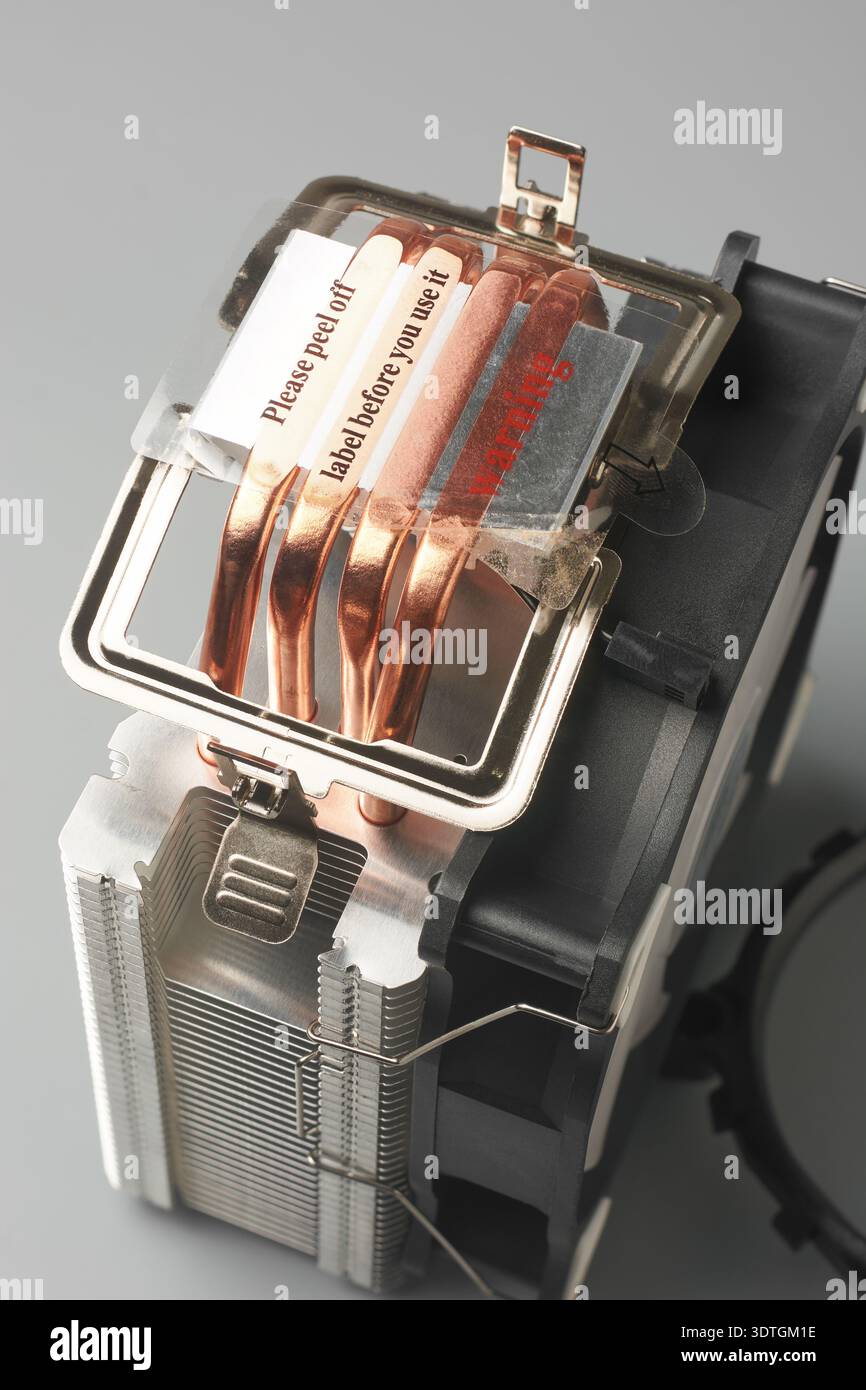 pellicola protettiva trasparente sul dissipatore di calore della cpu del computer sfondo neutro isolato, quattro tubi di calore in rame esposti e ventola in plastica nera Foto Stock