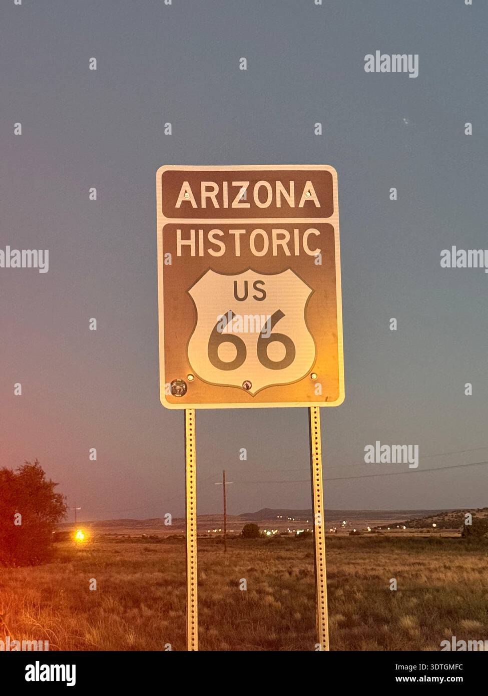 La storica segnaletica stradale della Route 66 in Arizona si trova accanto a un'autostrada nel deserto al tramonto, American Southwest, USA. Foto Stock