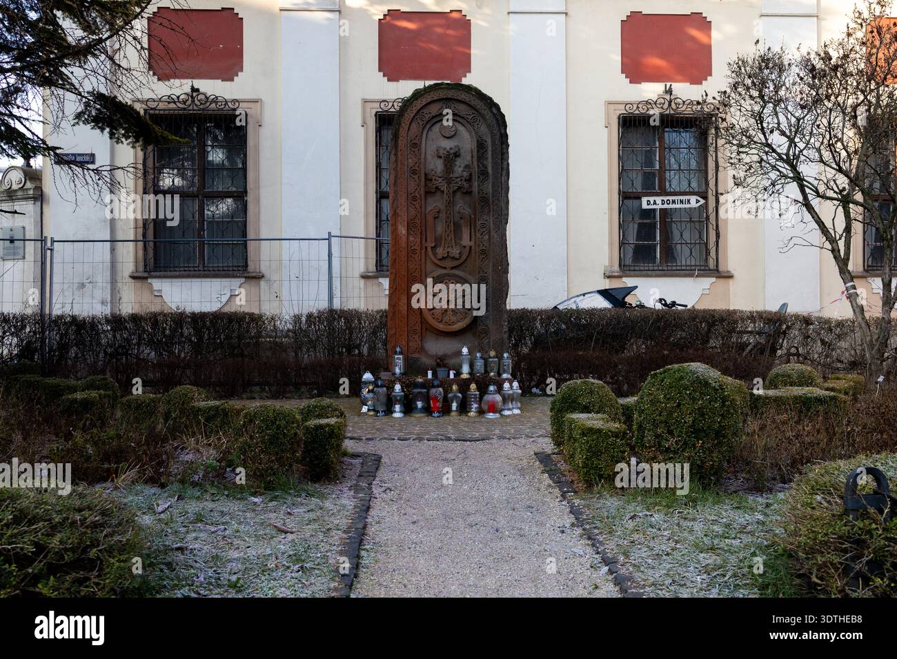 Sito commemorativo con candele e struttura in pietra di fronte a un edificio Foto Stock