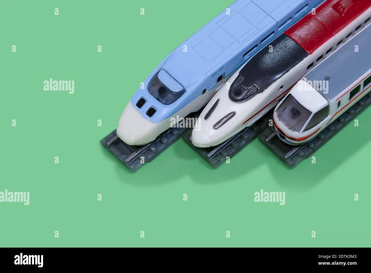Tre treni proiettili shinkansen in miniatura in piedi su binari della ferrovia giocattolo con spazio per copiare. Foto Stock