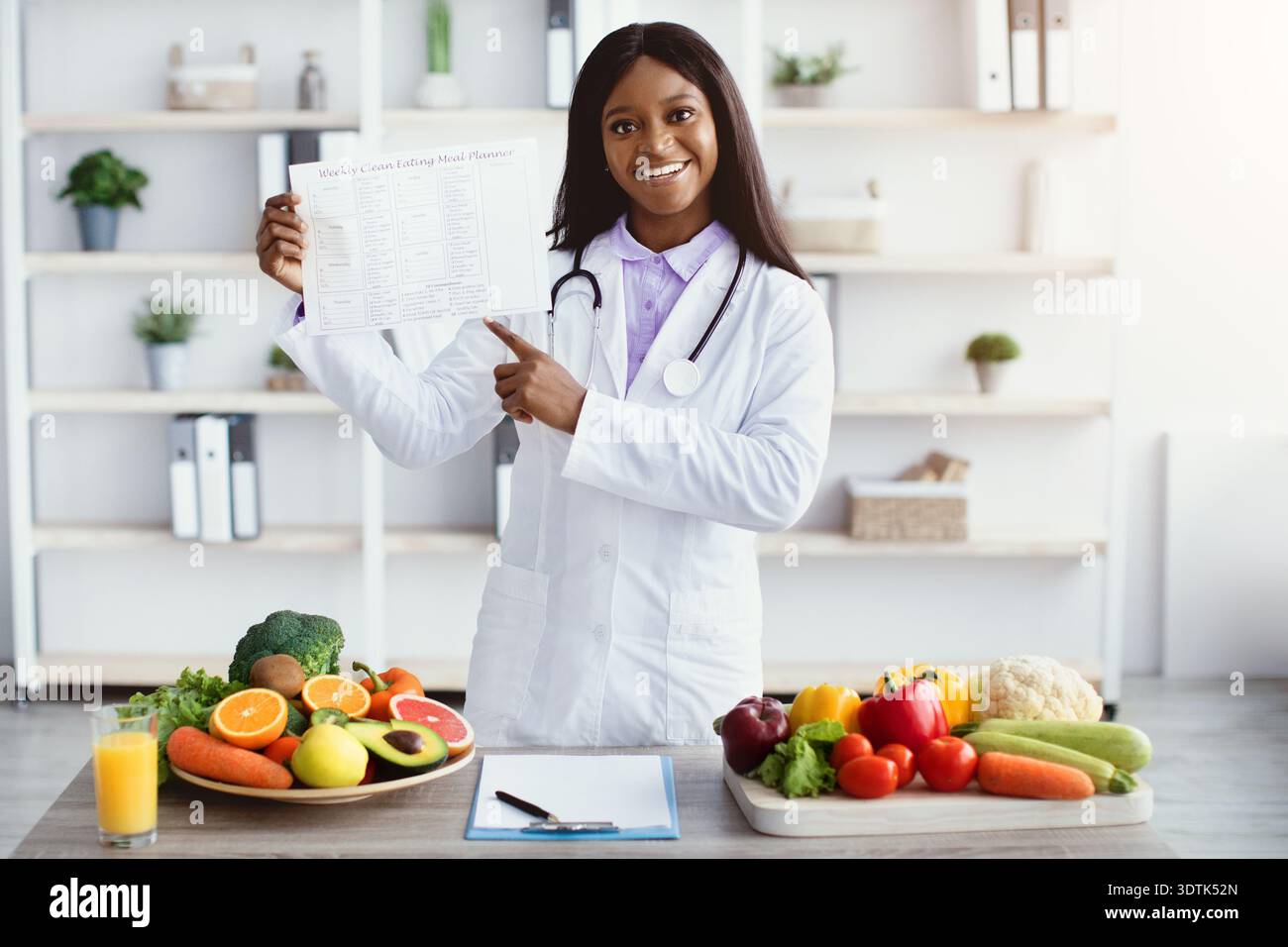 Dietitian mostra opzioni alimentari salutari e guida nutrizionale in un ambiente luminoso cucina Foto Stock