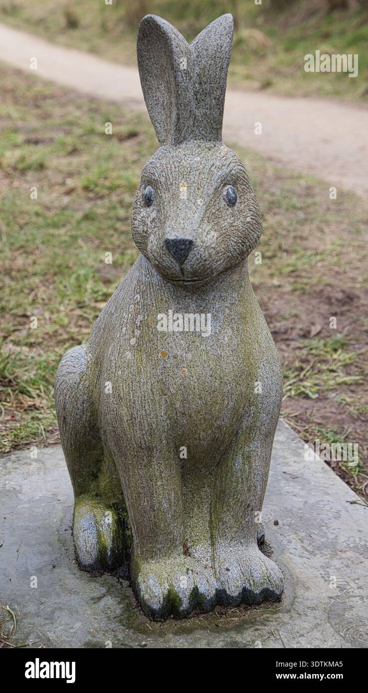 Una scultura di coniglio in cemento situata lungo un sentiero pubblico a Scammonden Reservoir, West Yorkshire, Inghilterra, caratterizzata da una struttura in pietra intemprata. Foto Stock