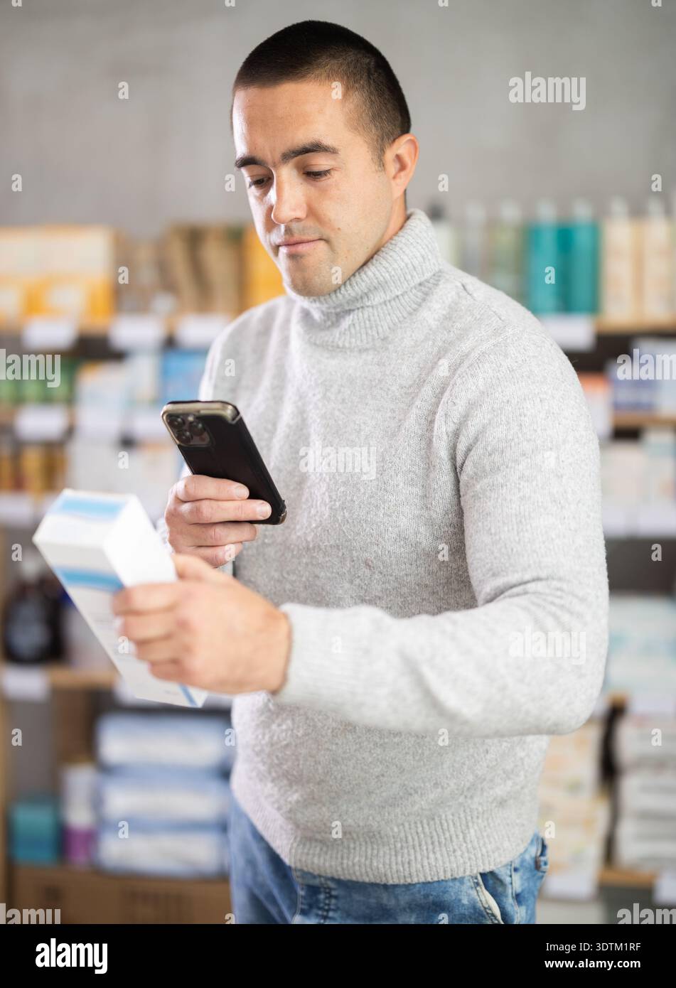 Man esegue la scansione del codice sulla confezione dell'unguento per controllare la data di scadenza Foto Stock