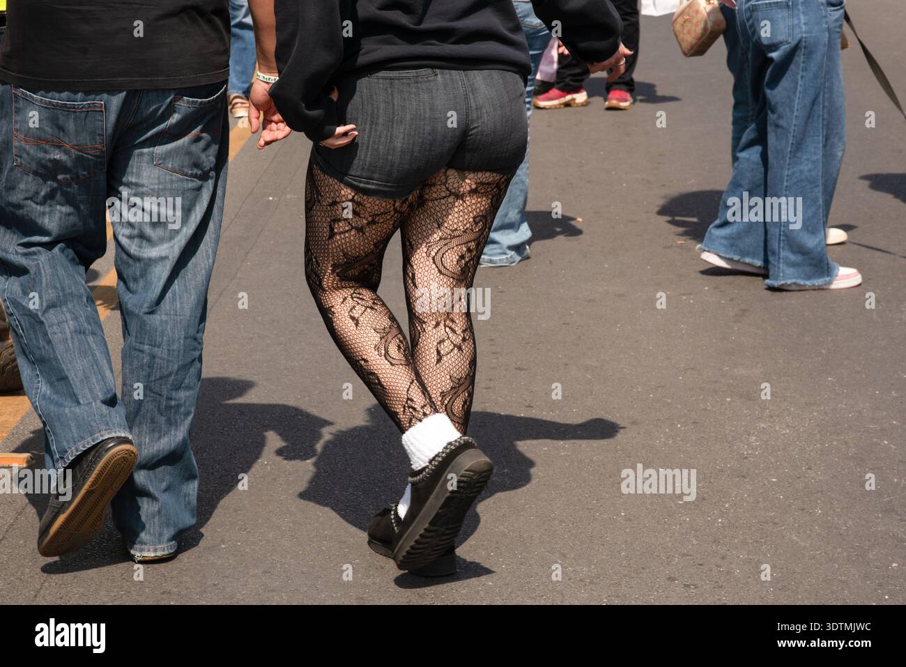 Le gambe di una donna vestita in modo informale con pantaloncini corti e calze a rete al Main Street Market di McAllen, Texas, USA. Foto Stock