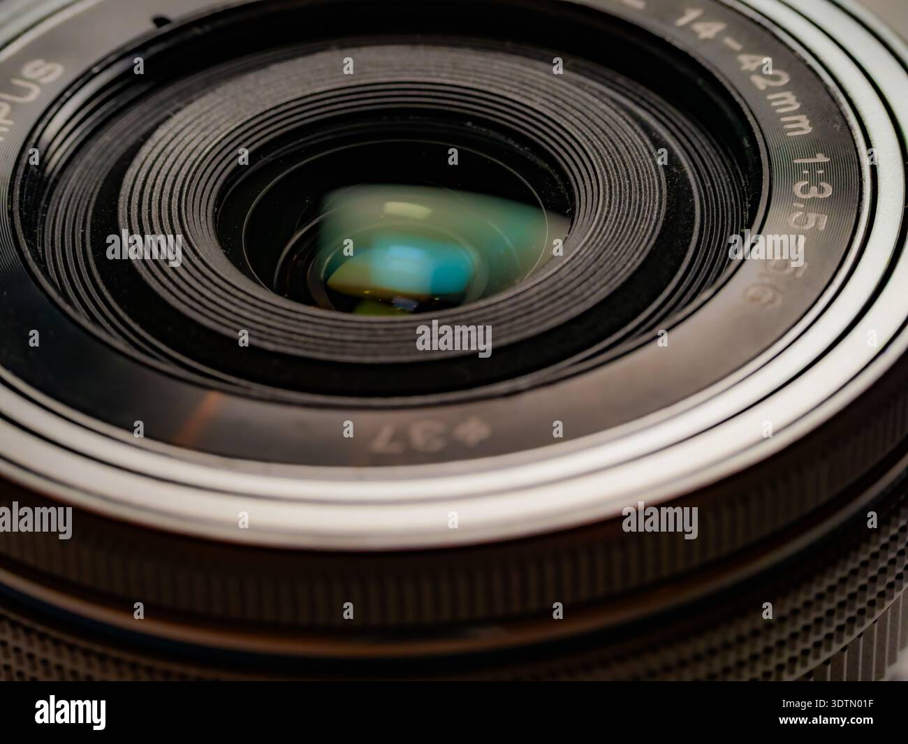 Primo piano estremo dell'obiettivo Olympus da 14 a 42 mm che mostra ottiche dettagliate e riflessi negli elementi in vetro Foto Stock
