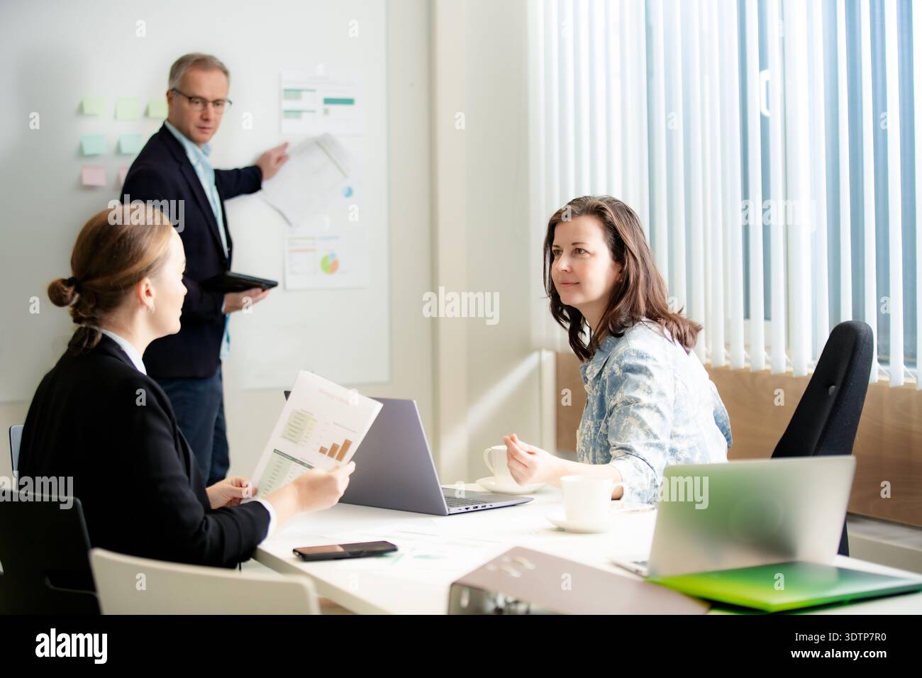 Professionisti specializzati che discutono di report. Collaborazione aziendale seria e pianificazione strategica in un team eterogeneo. Foto Stock