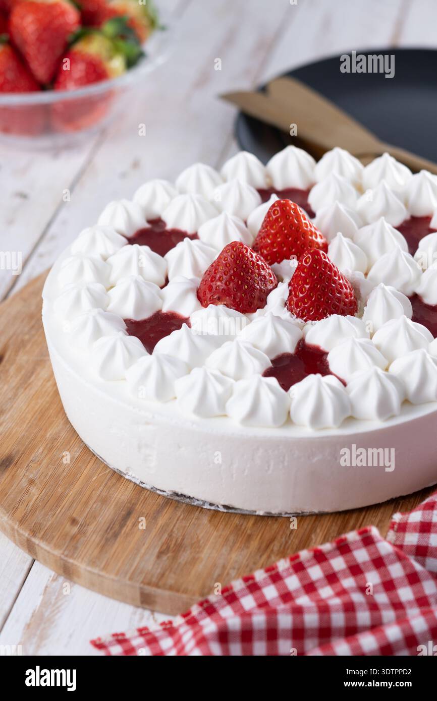Torta di fragole fresca con panna su un tavolo di legno bianco Foto Stock