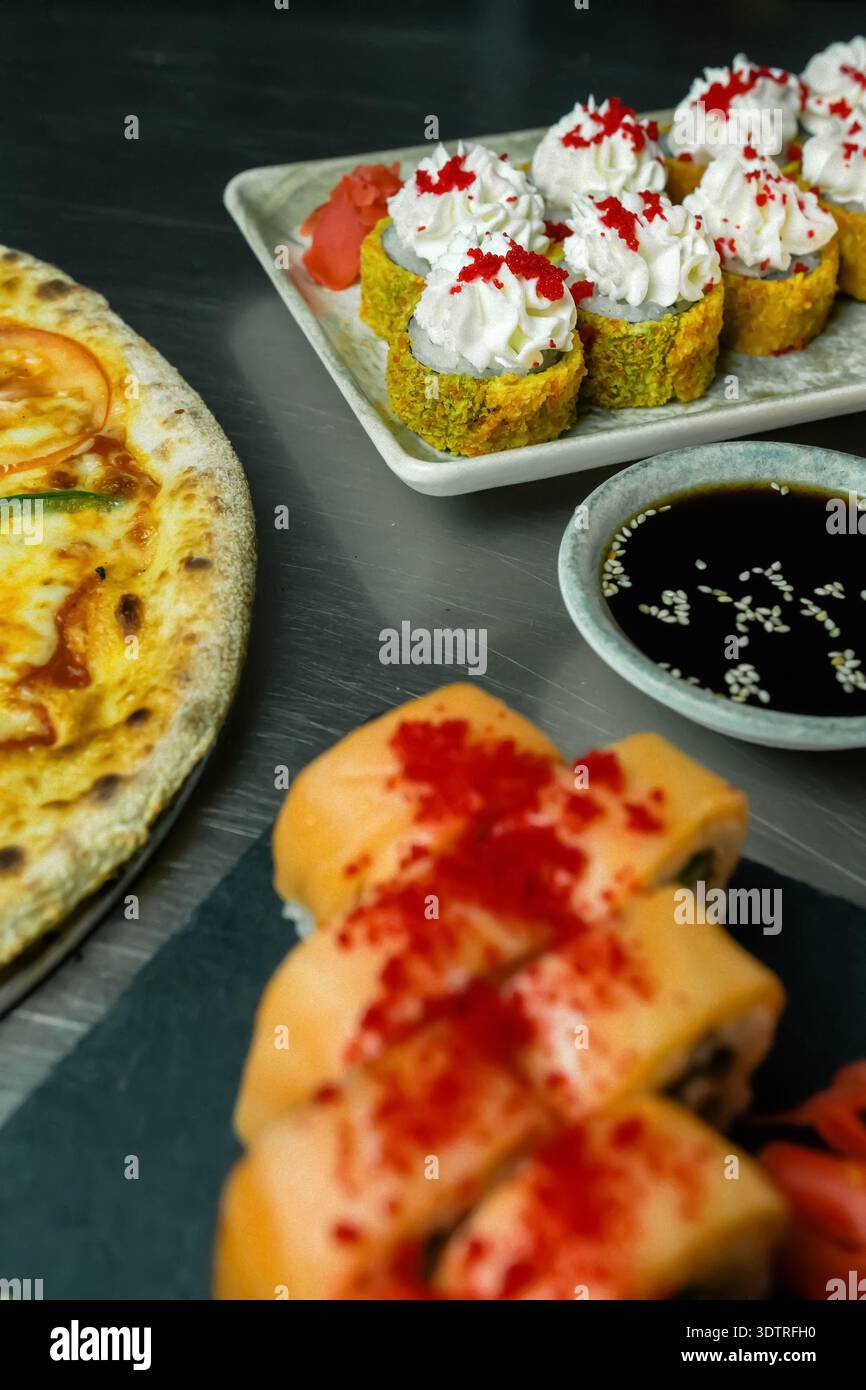 Una deliziosa fusione di sushi e pizza che mette in mostra creatività culinaria e diversità di sapori su un tavolo rustico Foto Stock