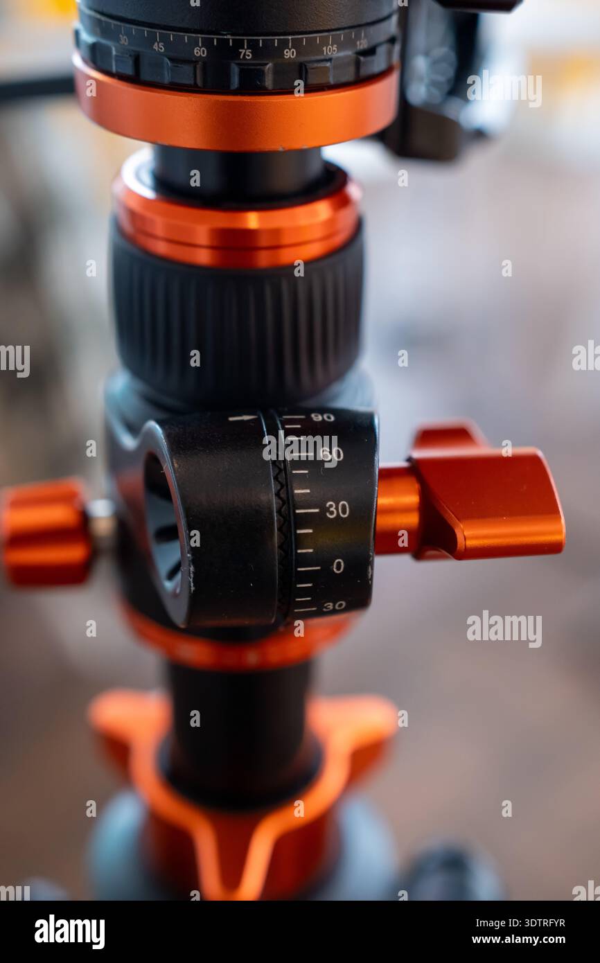 Vista ravvicinata della testa di un treppiede professionale con dettagli in arancione e nero, con regolazioni di precisione e funzioni di progettazione per Photography Enthus Foto Stock