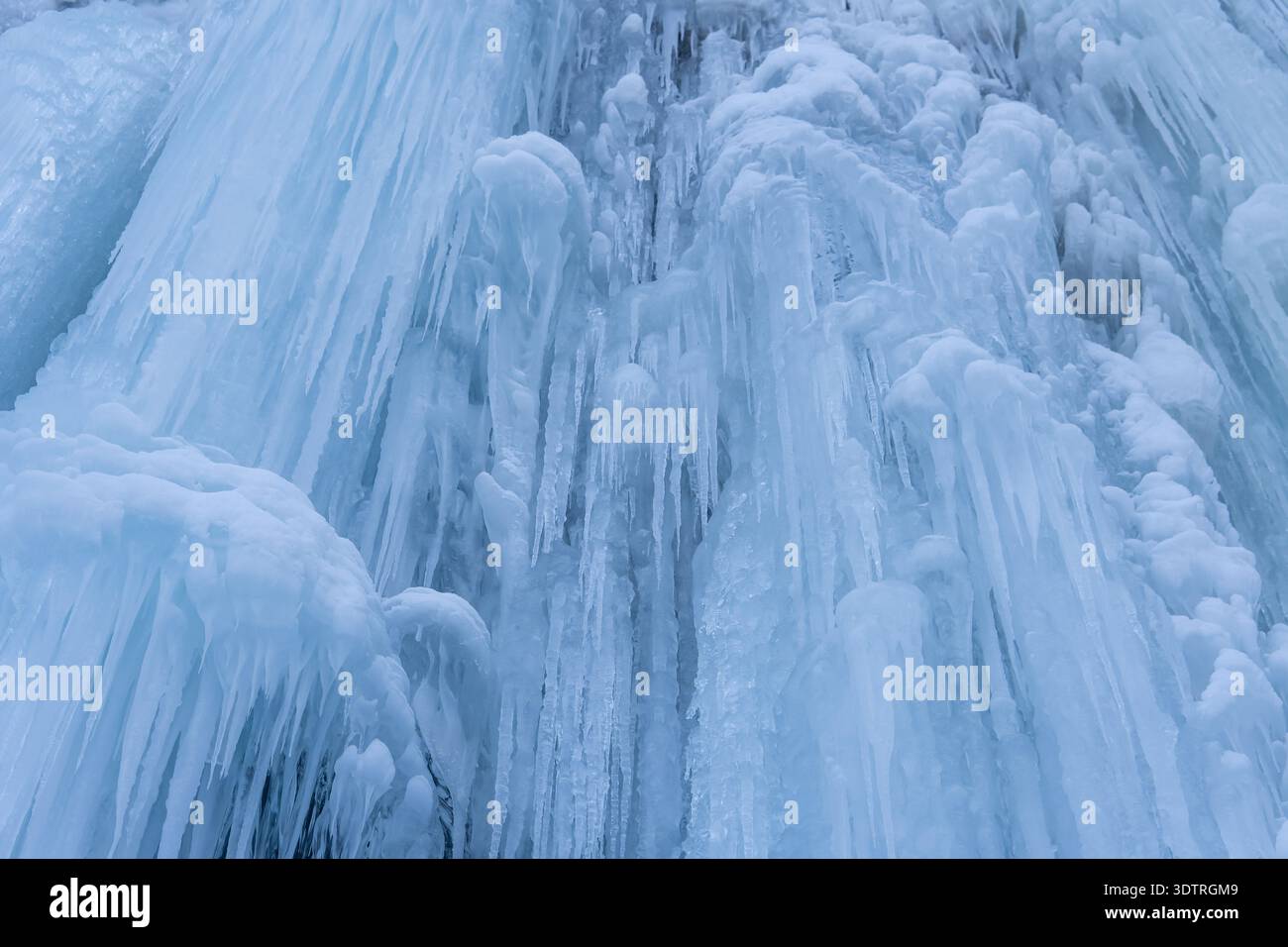 Un'accattivante esposizione di cascate ghiacciate che mostra le intricate formazioni di ghiaccio della natura e le strutture simili a cristalli sotto la luce Foto Stock