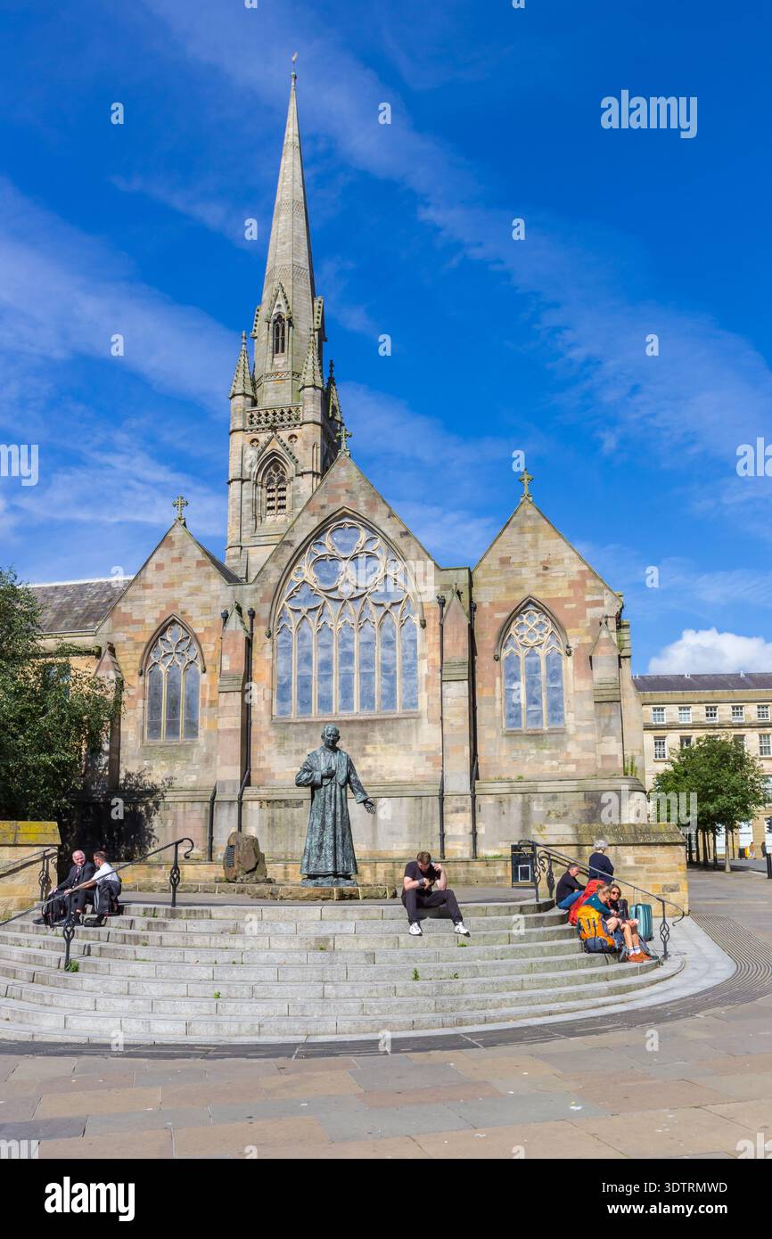 Persone sedute sui gradini di fronte alla cattedrale di Newcastle upon Tyne, in Inghilterra Foto Stock