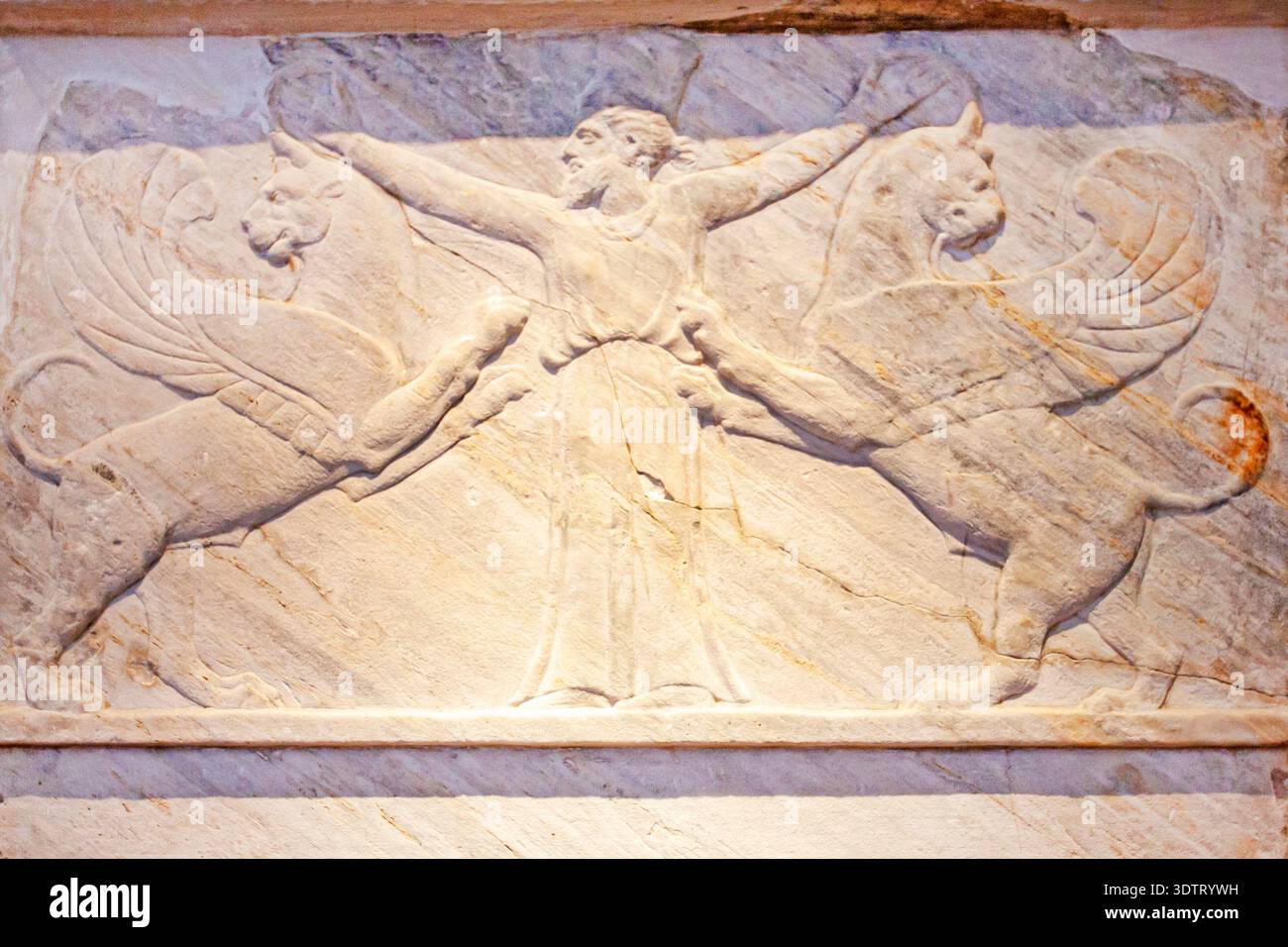 Antico rilievo in pietra tombale greco con una figura centrale di un uomo con due creature alate: Leoni o avvoltoi Foto Stock
