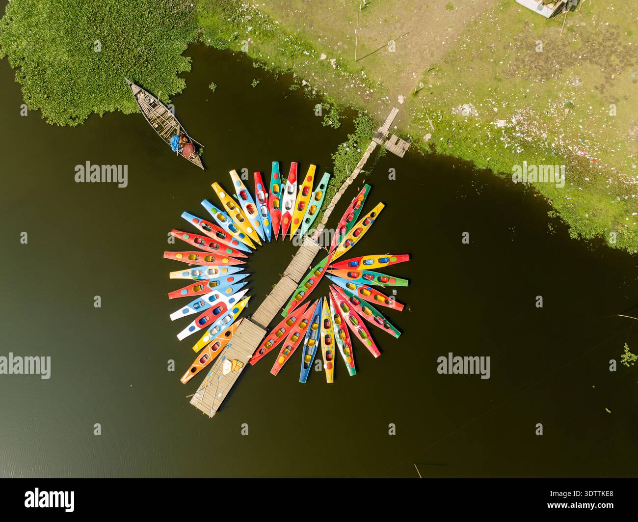 Vista aerea di una vivace gamma di kayak colorati raggruppati intorno a un piccolo molo di legno che si estende nelle acque ancora buie, Dacca, Divisione di Dacca, B. Foto Stock