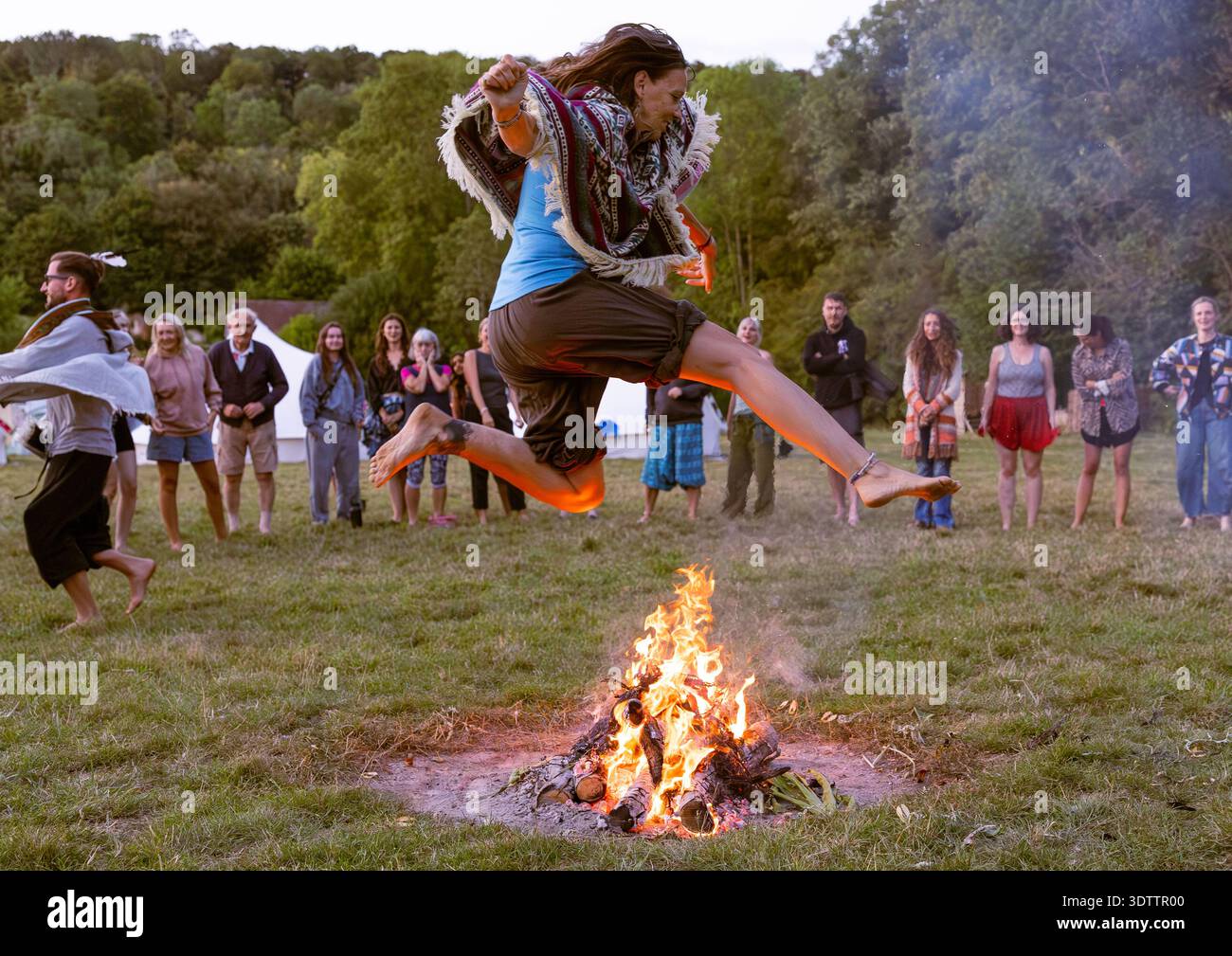 Salto con il fuoco al rifugio yoga nella campagna inglese Foto Stock