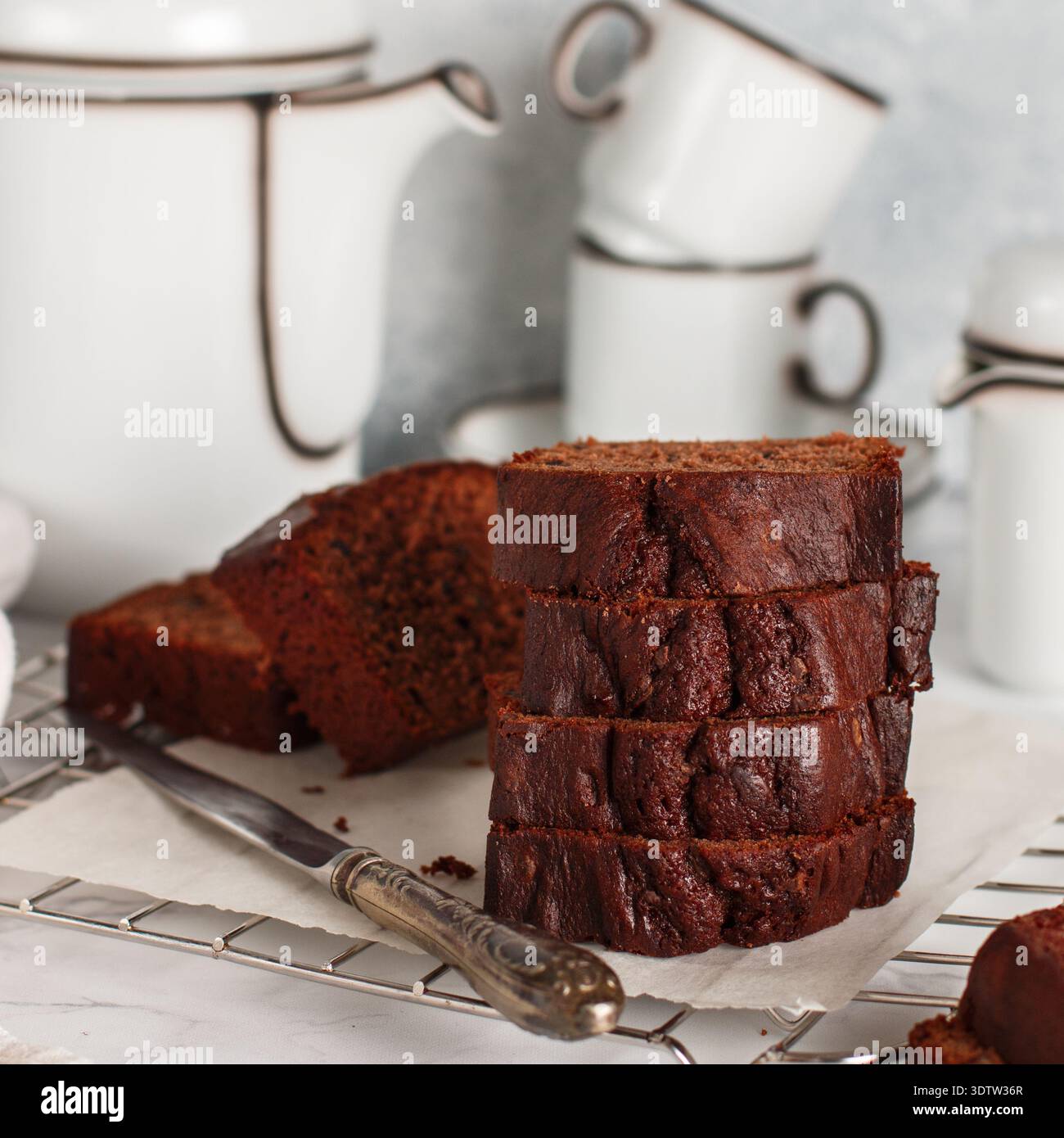 Pane per torte fatto in casa con chili di cioccolato a fette. Delizioso dessert. Una delizia per tè o caffè. Colazione su un tavolo di marmo contro un muro di cemento grigio. SEL Foto Stock
