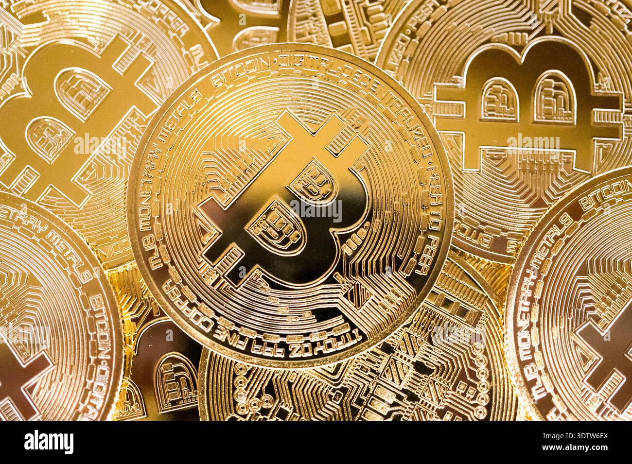 Primo piano di monete Bitcoin in oro sovrapposte con simbolo in rilievo e motivi simili a circuiti, sfondo lucido per finanza cripto metallico. Foto Stock