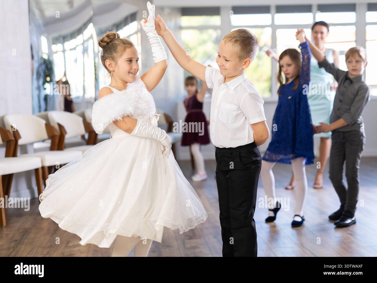 Entusiasti bambini preadolescenti che ballano valzer a coppie nella scuola di danza Foto Stock