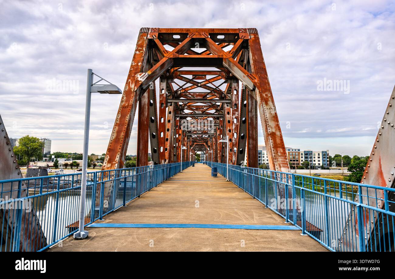 Passerella pedonale sul ponte di giunzione arrugginito in acciaio sul fiume Arkansas, con il sottomarino USS Razorback visibile a Little Rock, Arkansas, Stati Uniti. Foto Stock