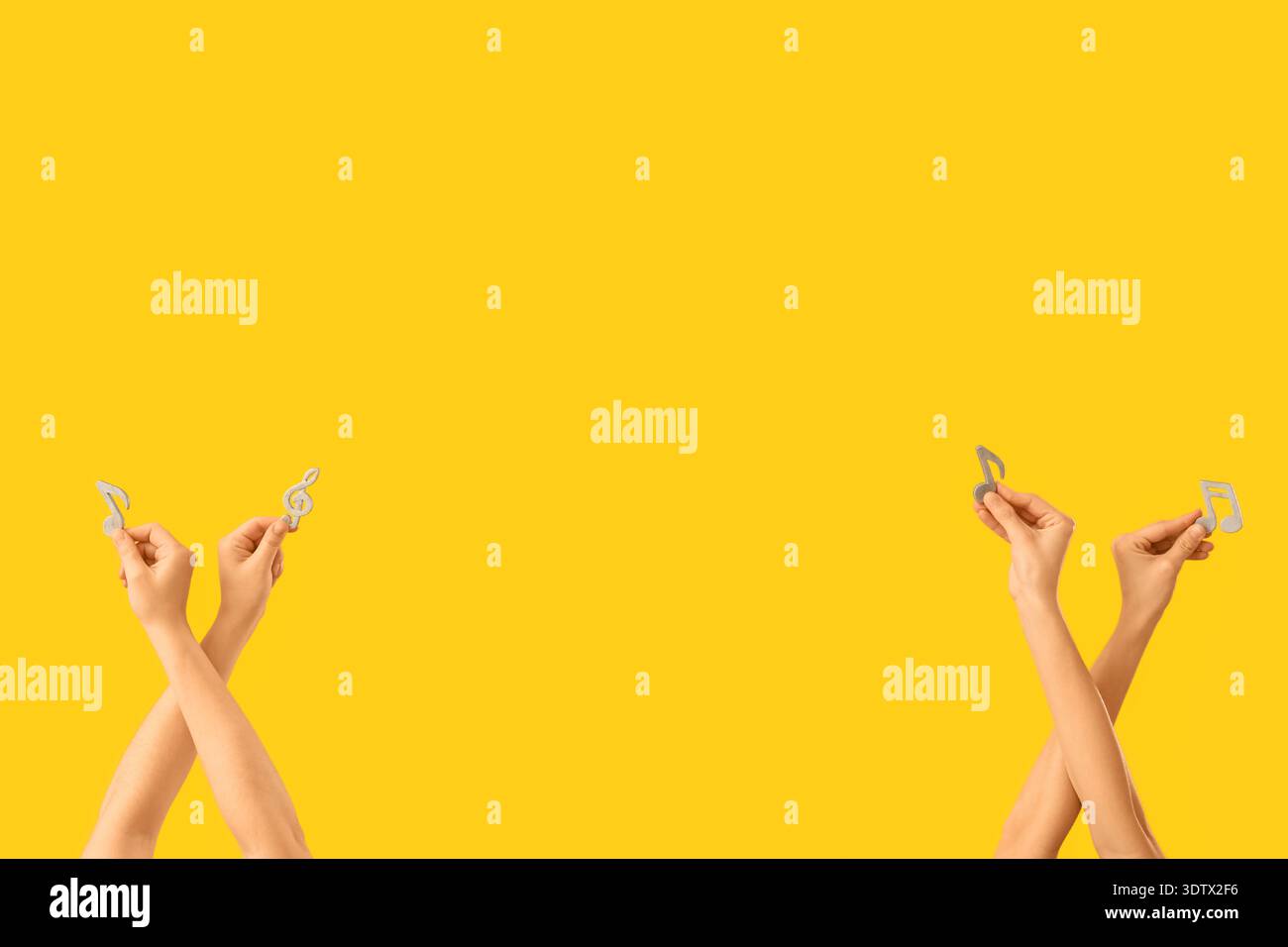 Mani femminili con note musicali su sfondo giallo Foto Stock