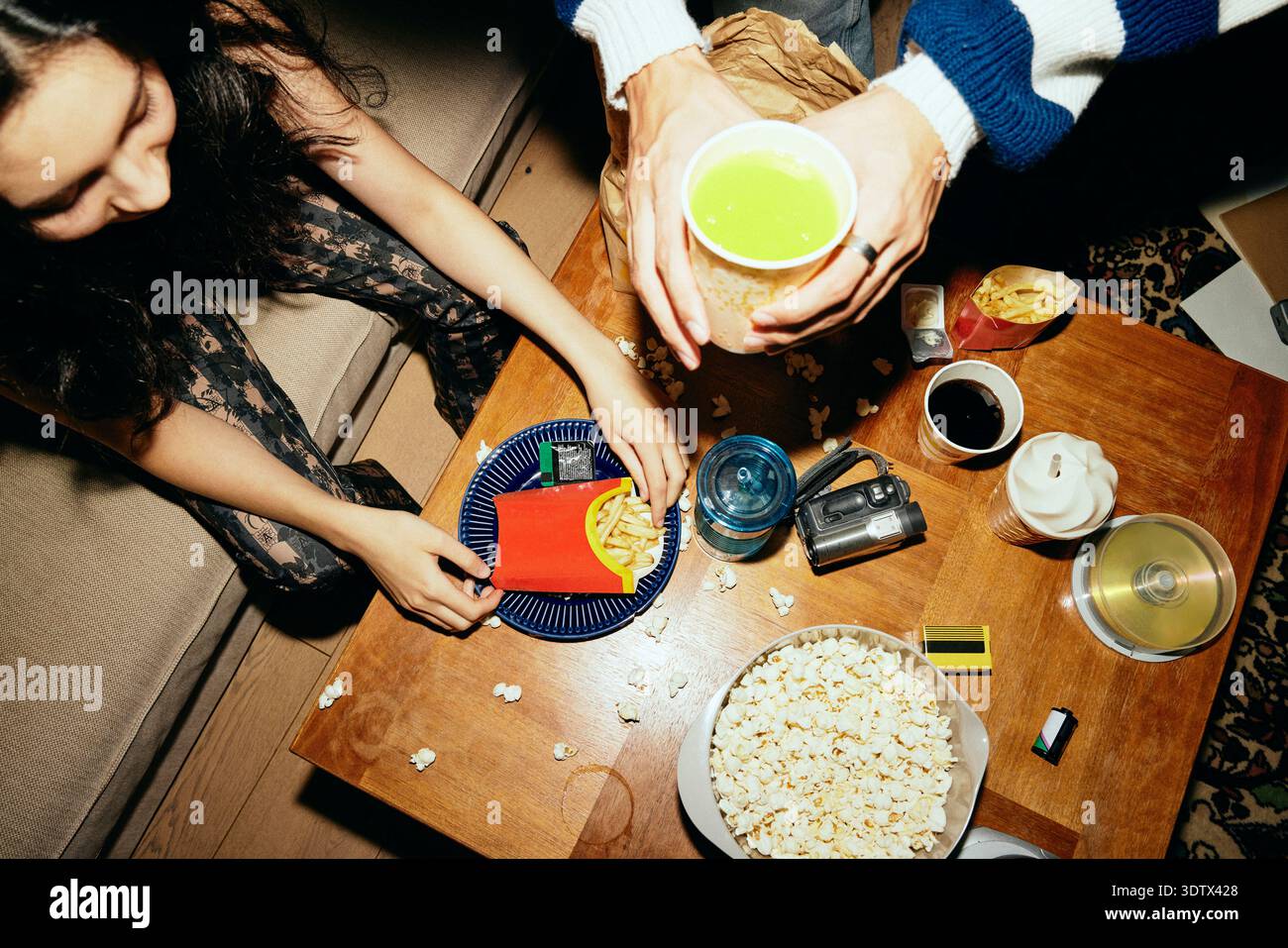 Vista dall'alto dell'uomo e della donna che si godono i fast food e le bevande a casa Foto Stock