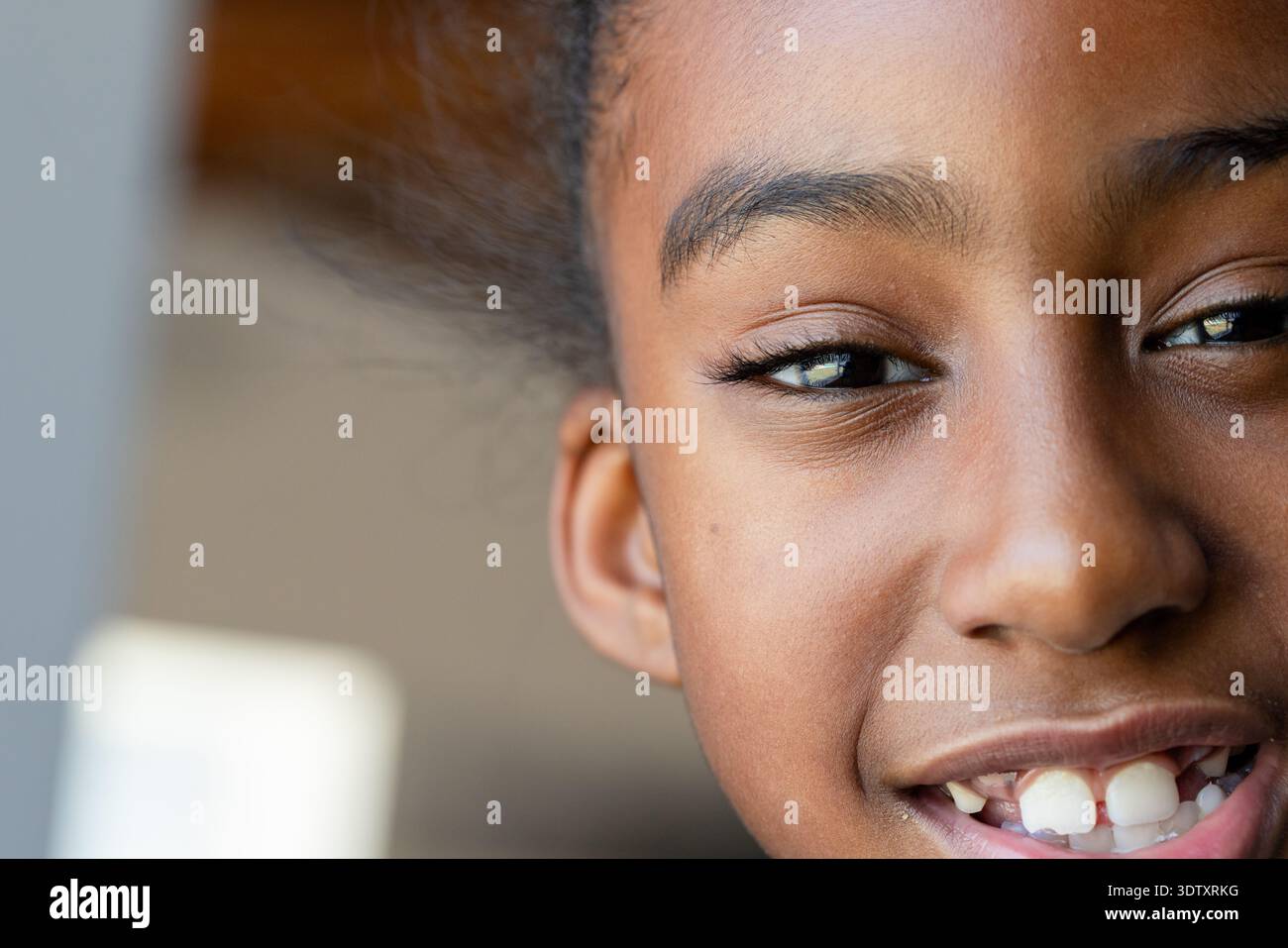 La faccia destra mostra la consistenza della pelle, le ciglia e lo spazio anteriore tra i denti vicino alla finestra Foto Stock