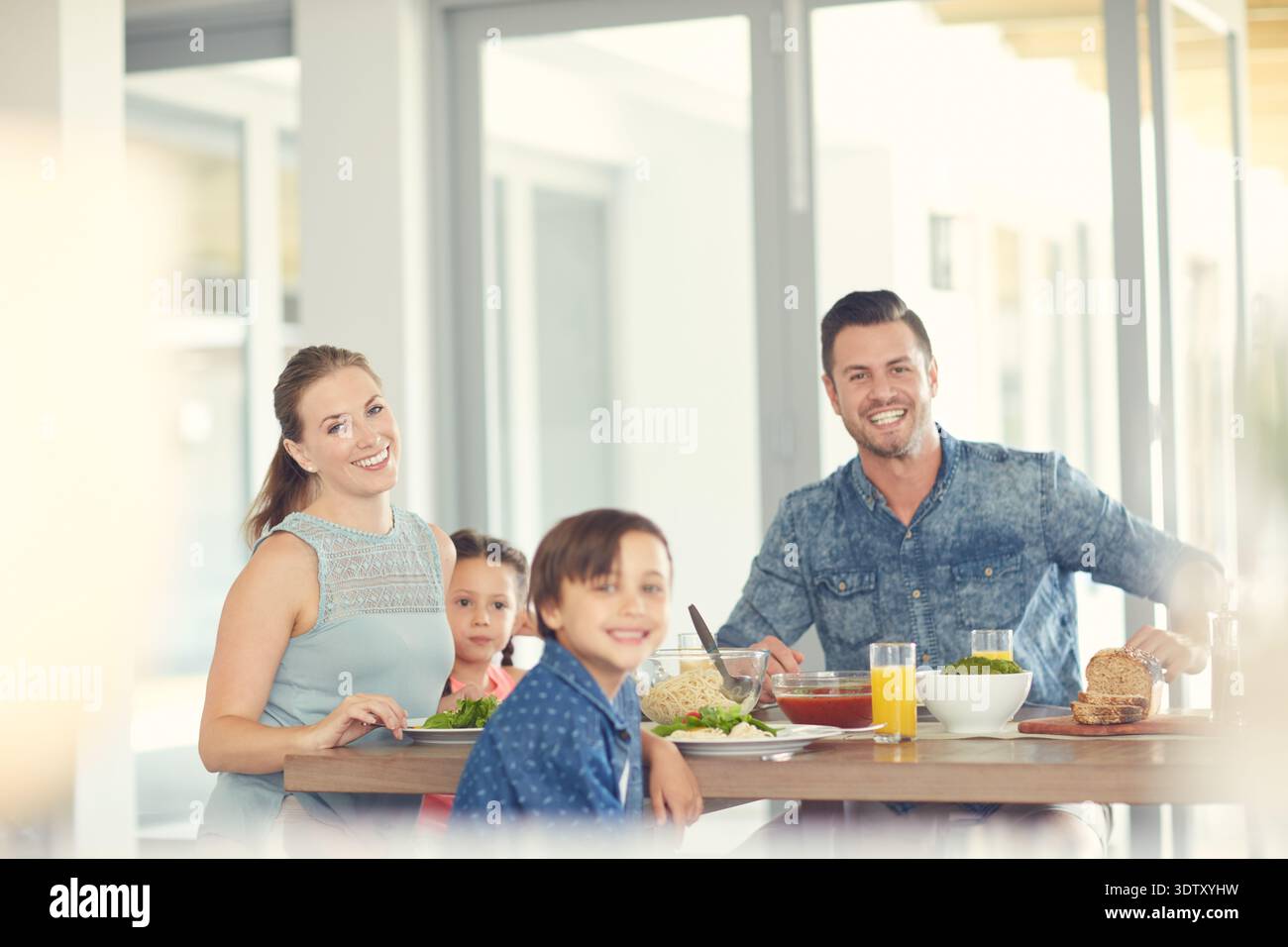 Famiglia felice, cena e cena con i bambini a casa per un pranzo, un pasto o uno spuntino affamato insieme. Ritratti, mamma e papà con bambini, sorrisi o cibo per Foto Stock