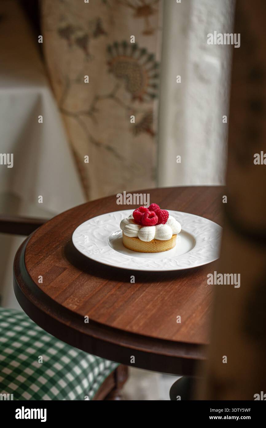 Crostata di lamponi con panna montata sul piatto Foto Stock