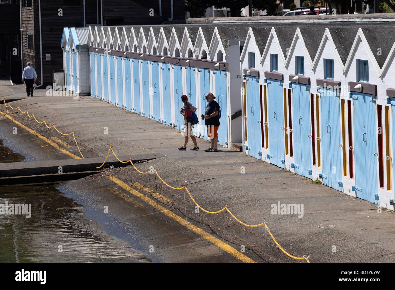 Fila di colorate capanne per barche che si riflettono sull'acqua sul lungomare di Wellington, nuova Zelanda. Foto Stock