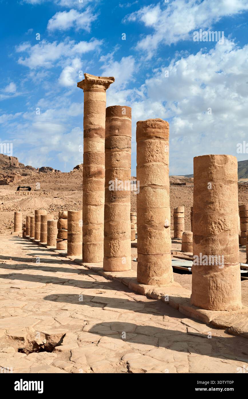 I turisti visitano la porta Adriana a Petra, esplorando antiche colonne sotto il cielo blu. Il sito è una parte fondamentale della ricca storia della Giordania. Foto Stock