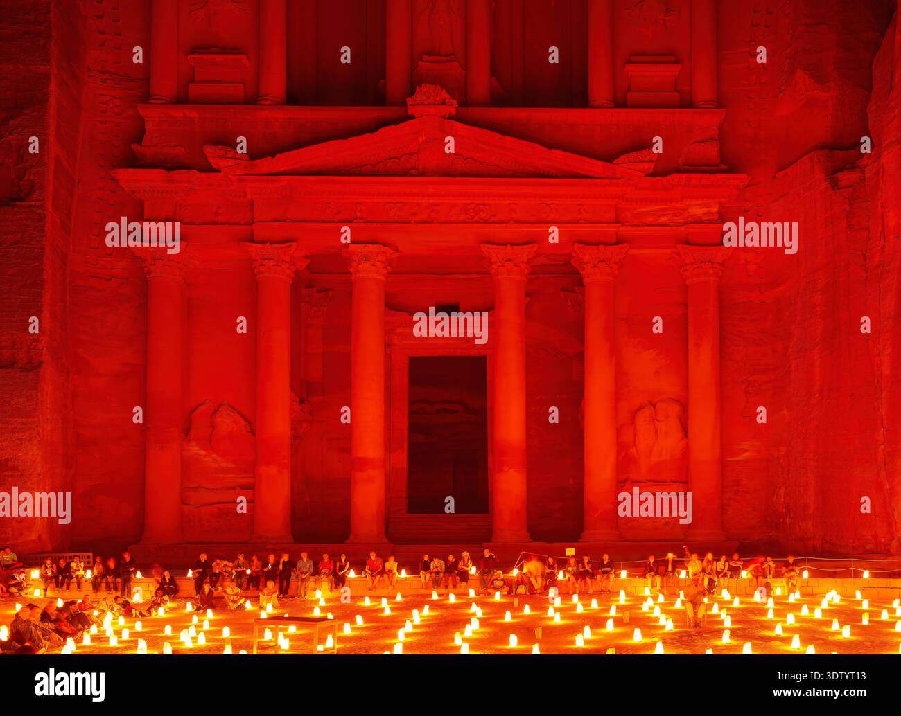 I visitatori potranno assistere a un evento a lume di candela di fronte ad al Khazneh, il Tesoro, a Petra, in Giordania, creando un caldo bagliore nell'antico sito. Foto Stock
