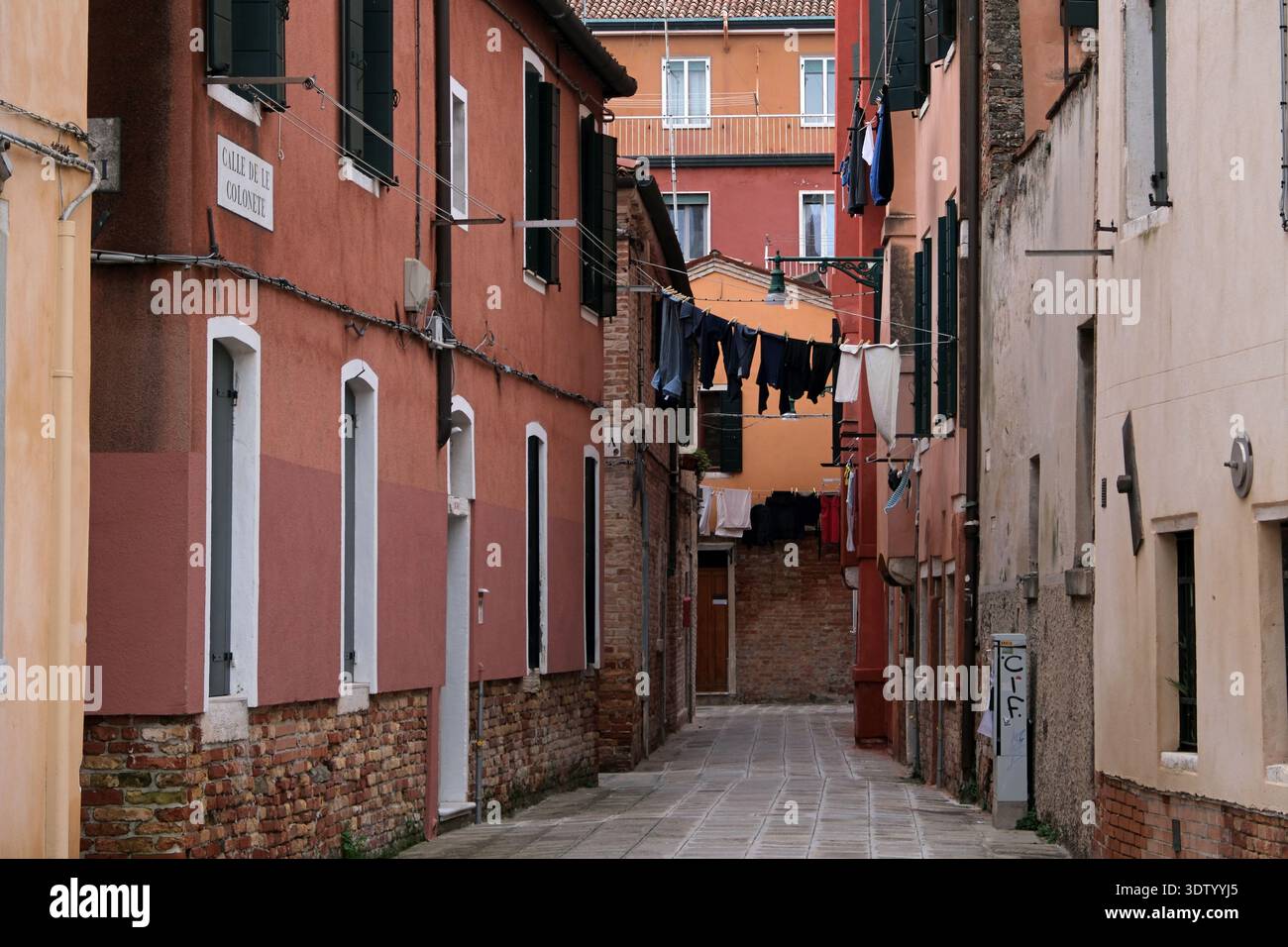 Via secondaria a Venezia con bucato appeso tra gli edifici, Venezia, Italia Foto Stock