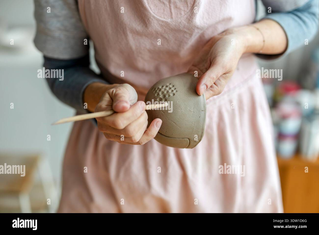 Primo piano delle mani di un vasaio che lavorano con oggetti di argilla nel suo laboratorio Foto Stock