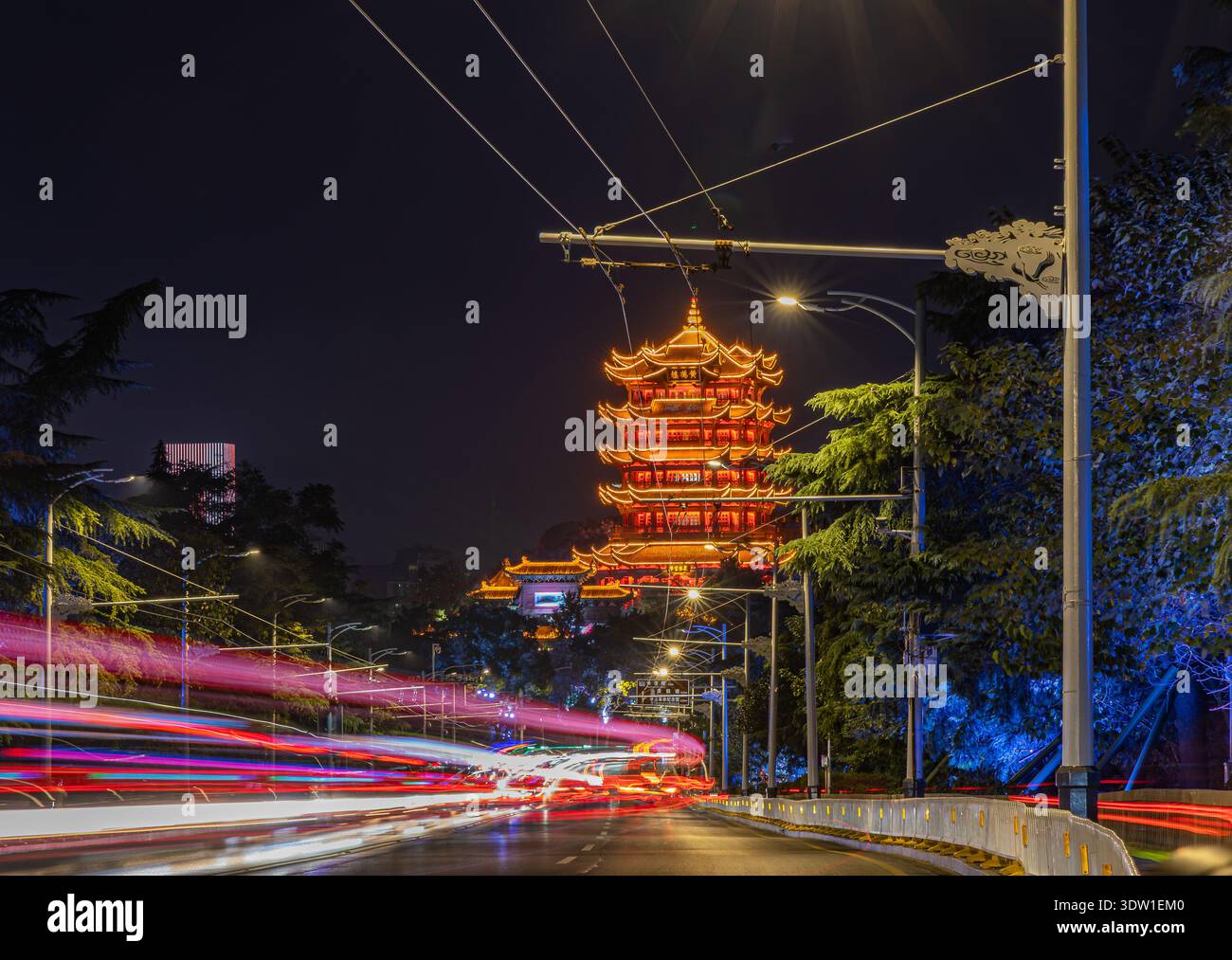 La pagoda della gru gialla di Wuhan è vista dal ponte lungo sul fiume con sentieri leggeri in auto in serata Foto Stock