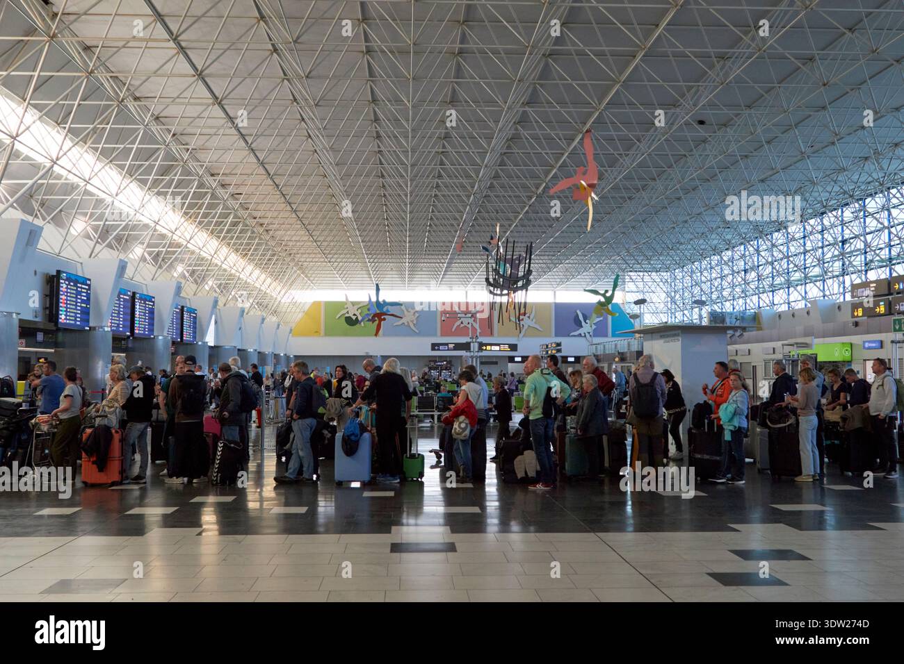 i turisti fanno la fila per il check-in nella sala partenze dell'aeroporto di gran canaria, isole canarie, spagna Foto Stock