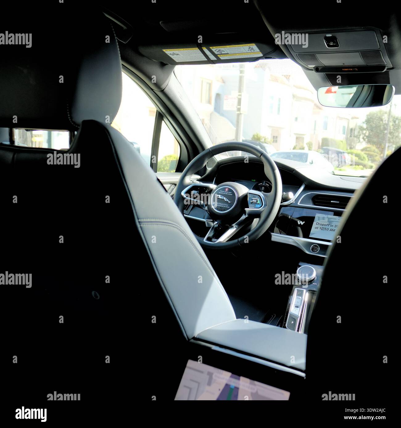 Volante, cruscotto, console centrale all'interno di un robotaxi autonomo Waymo; abitacolo della vettura. Foto Stock