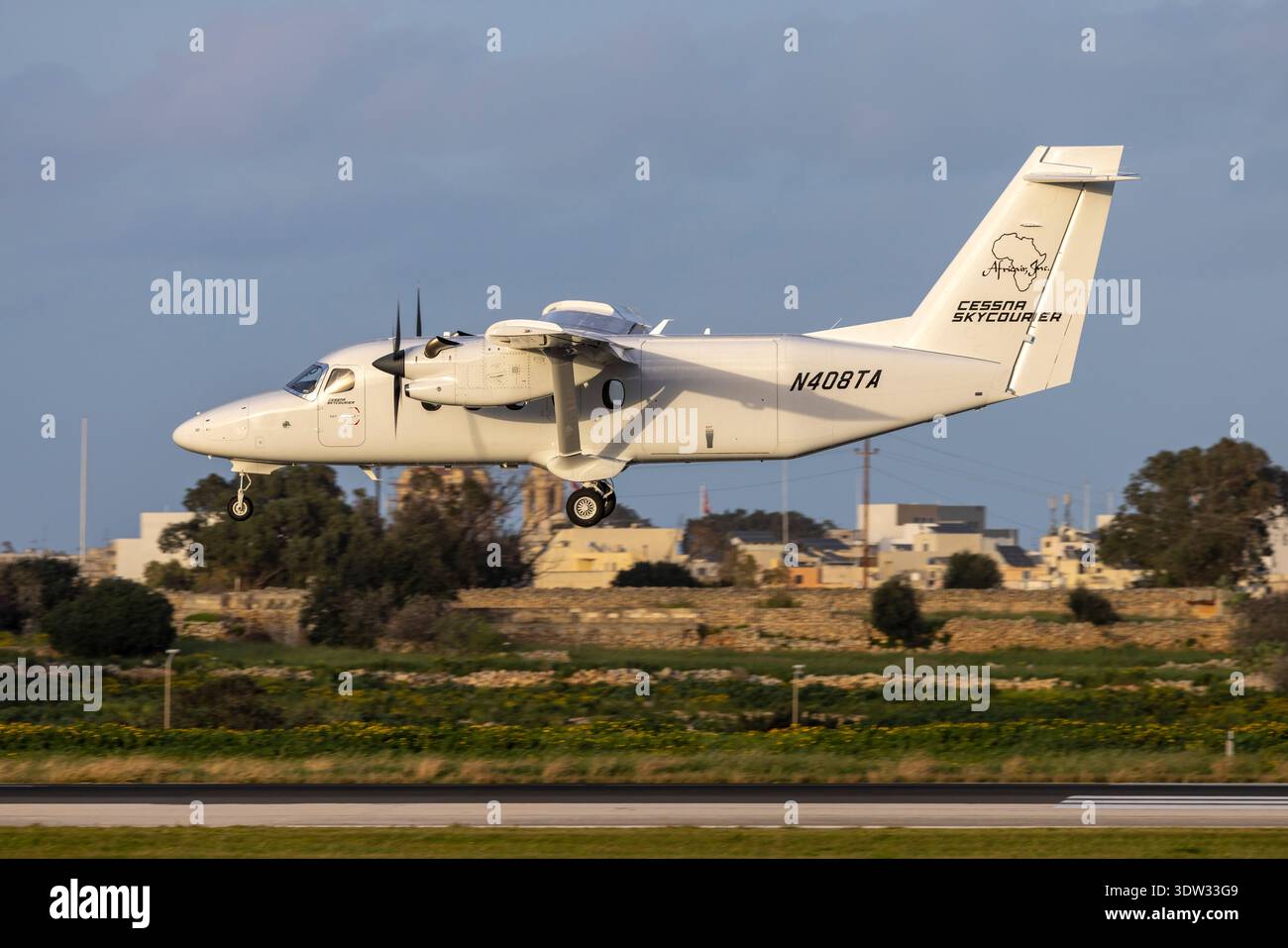 Africair Cessna 408 SkyCourier (REG: N408TA) atterrando in tarda serata quando il sole scoppia tra le nuvole. Foto Stock