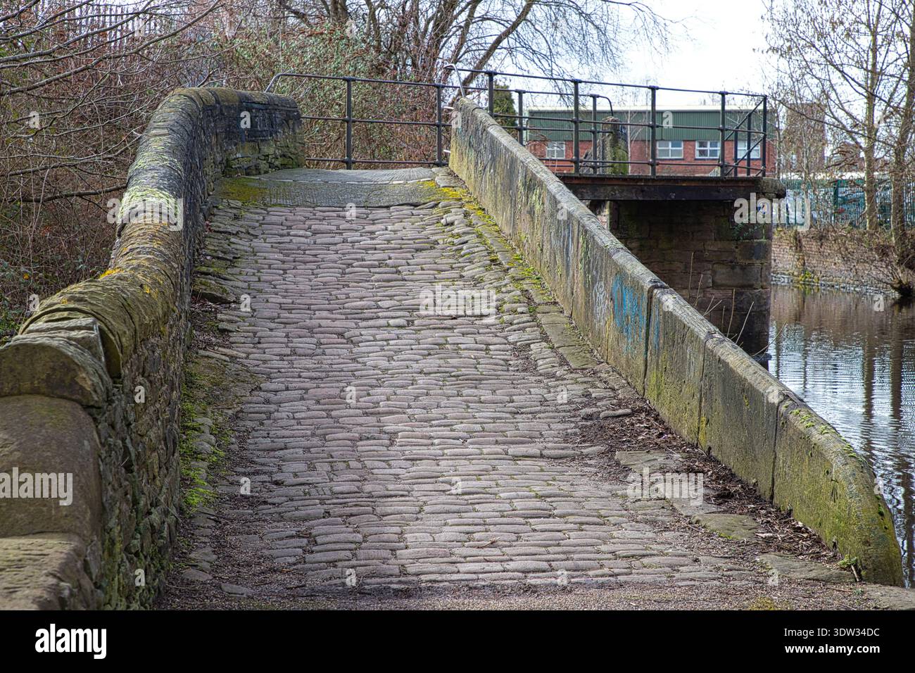 Ponte di ciottoli in pietra sul canale Ashton, Tameside, Regno Unito. Foto Stock