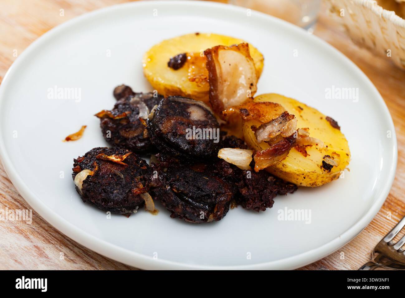 Fritto rustico gustoso salame di sangue con patate servito a piatto Foto Stock