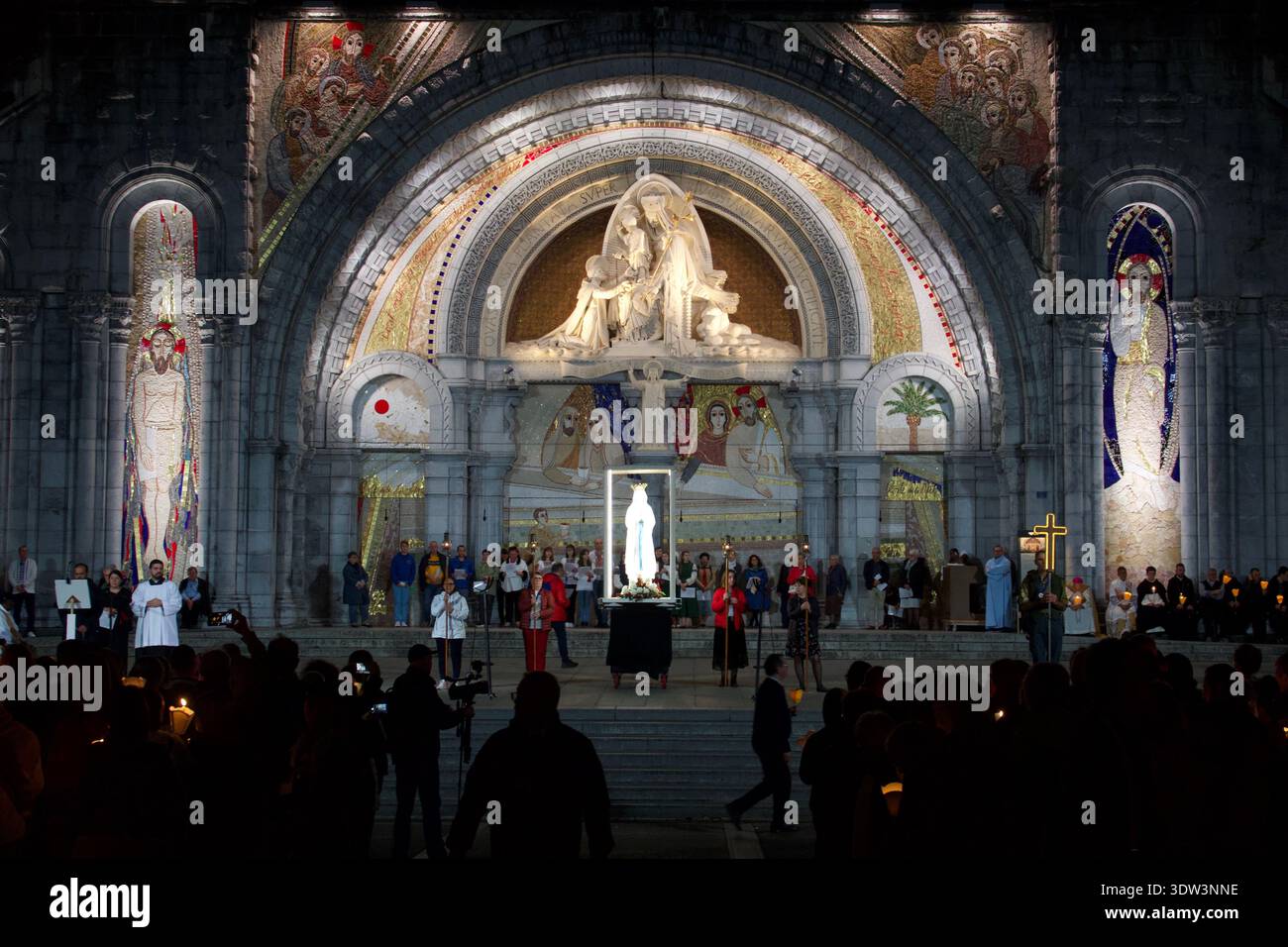 Statua della Vergine Maria fuori dalla Basilica di Lourdes di notte Foto Stock
