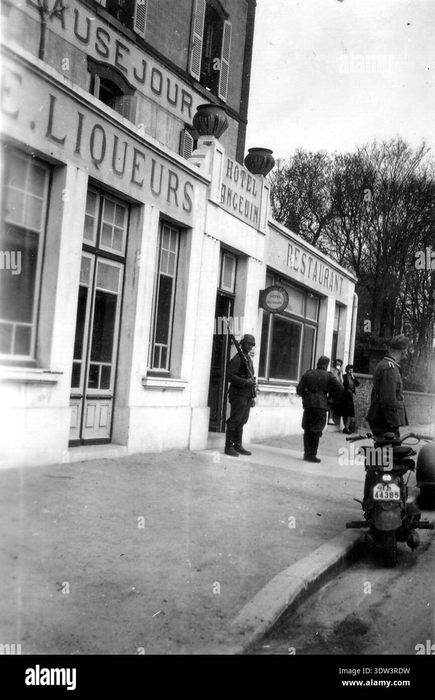 Due soldati tedeschi che parlano con due donne francesi fuori da un ristorante a Donville les Bains. Foto Stock