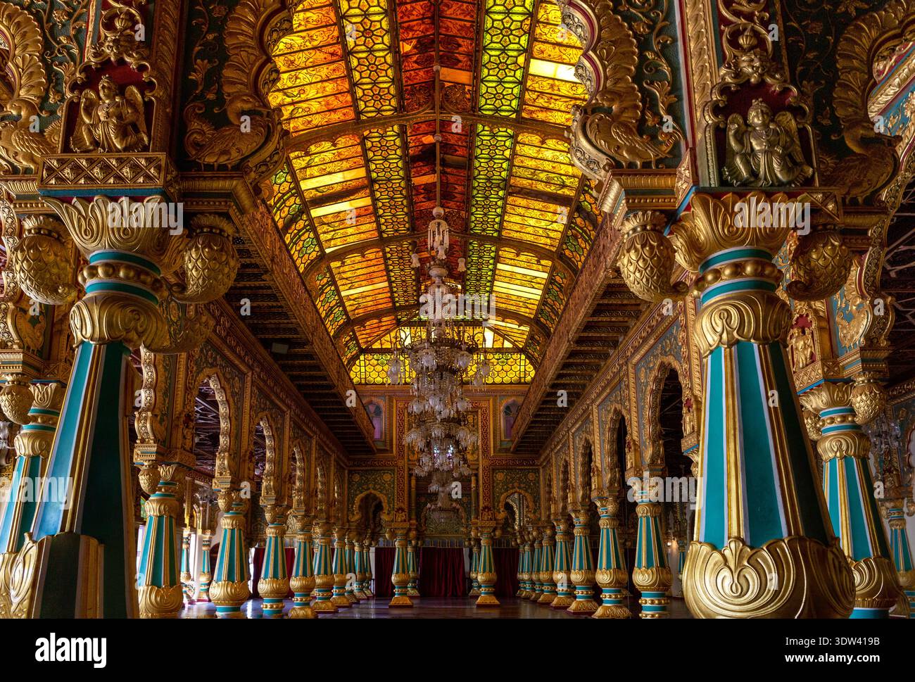 Una vista mozzafiato dell'interno di un grande palazzo a Karnataka, India, che mostra una squisita architettura e intricati disegni di vetrate colorate. Foto Stock