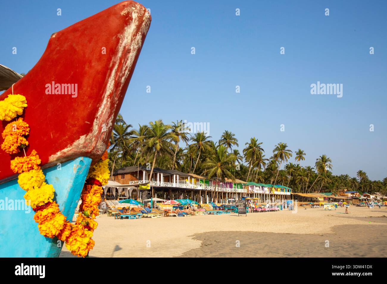 Vivace scenario di spiaggia a Goa, India, con baracche colorate e palme. Foto Stock