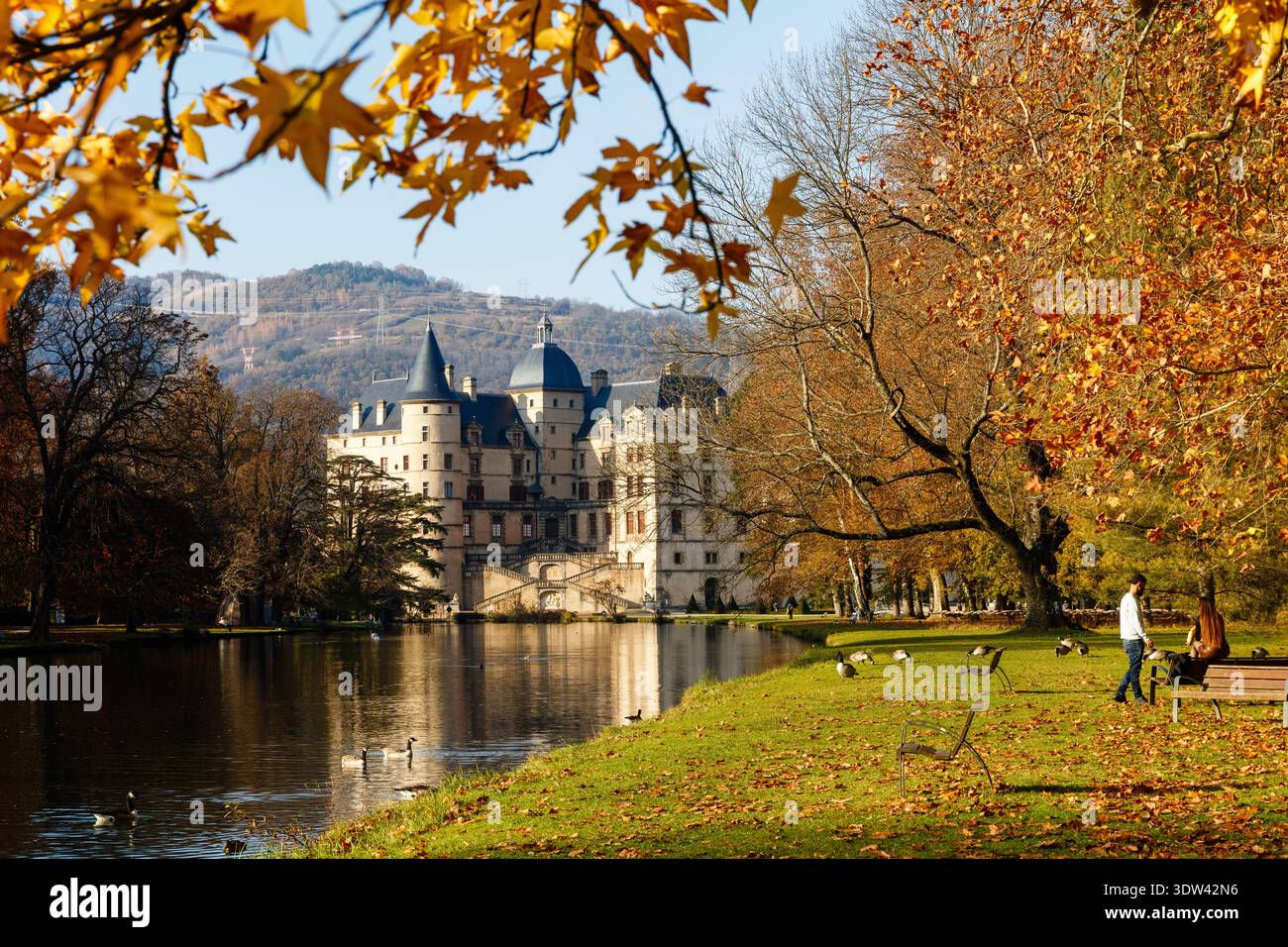 Un tranquillo scenario autunnale caratterizzato da un castello storico vicino a un lago. Foto Stock