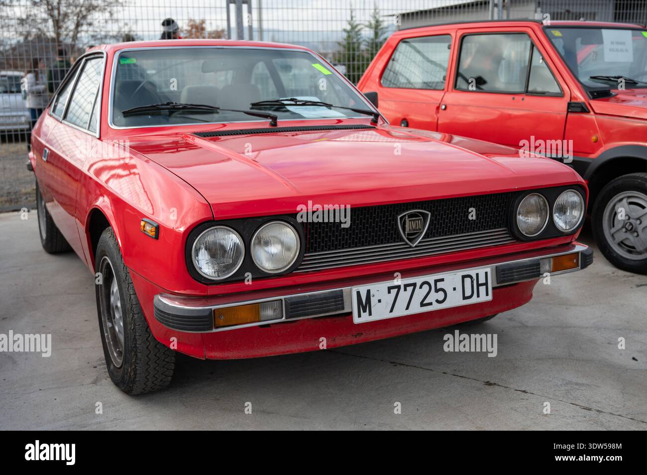 Vista frontale di una classica Lancia Beta Coupé rossa con fari quadrupli rotondi e finiture cromate parcheggiata in occasione di un evento automobilistico all'aperto. Foto Stock