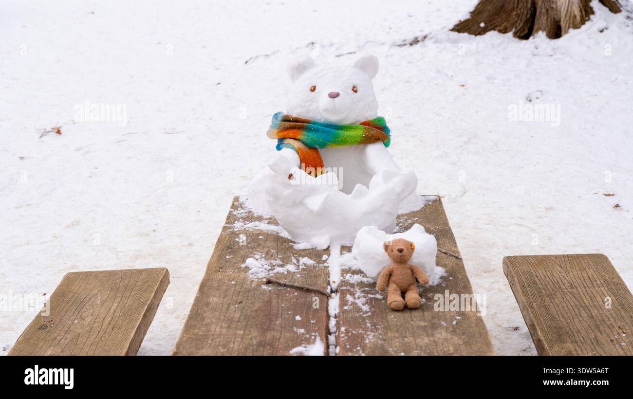 Una scultura creativa di orso della neve con una sciarpa nei boschi innevati fuori dal santuario Hokkaido Jingu a Sapporo, Giappone, il 27 febbraio 2026. Foto Stock