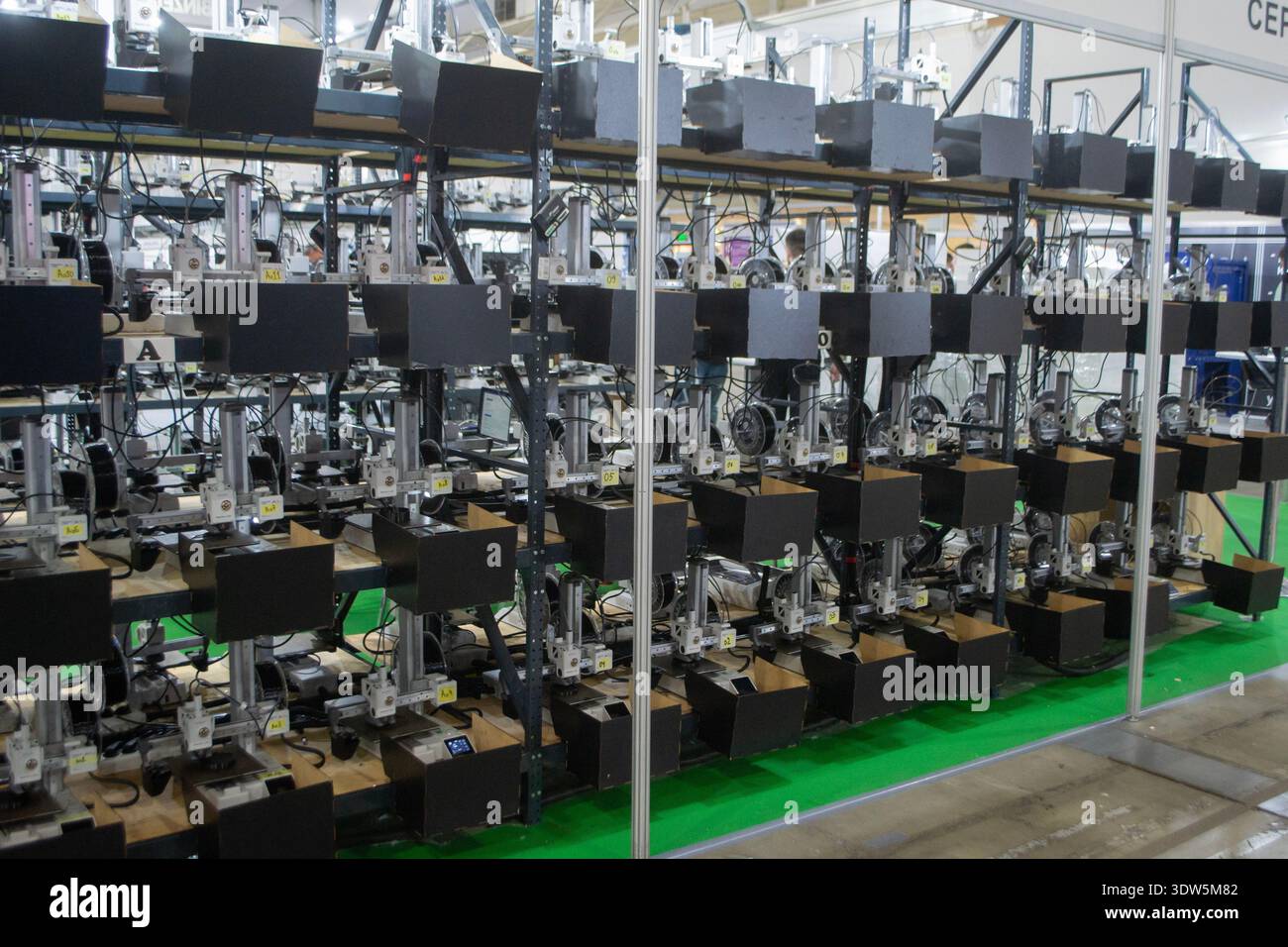 Molte stampanti 3D stampano un oggetto. Stampanti 3D che stampano contemporaneamente modelli da plastica fusa. Molte stampanti 3D creano forme da plastica fusa che fuoriesce dall'estrusore. Tecnologia di stampa 3D. Foto Stock